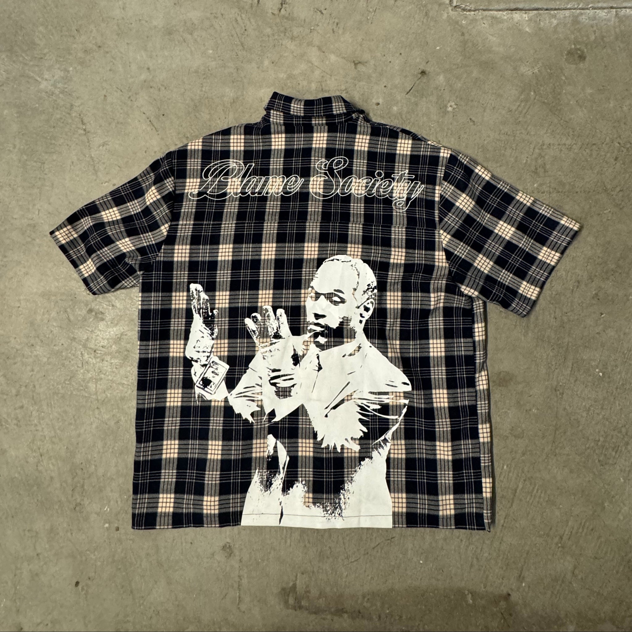 Plaid shirt with graphic design on a concrete surface